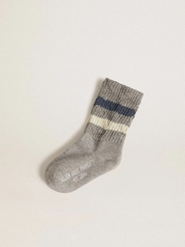 Calzini grigi da bambino con dettagli consumati e strisce bianche e blu dall’effetto consumato