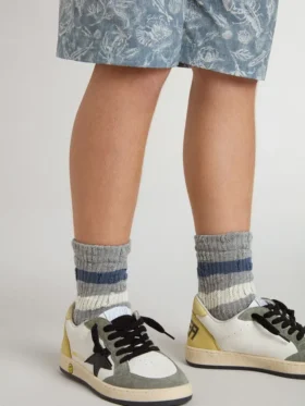 Calzini grigi da bambino con dettagli consumati e strisce bianche e blu dall’effetto consumato
