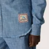 Camicia unisex Journey in chambray di cotone azzurro con orlo sfrangiato e toppa ricamata