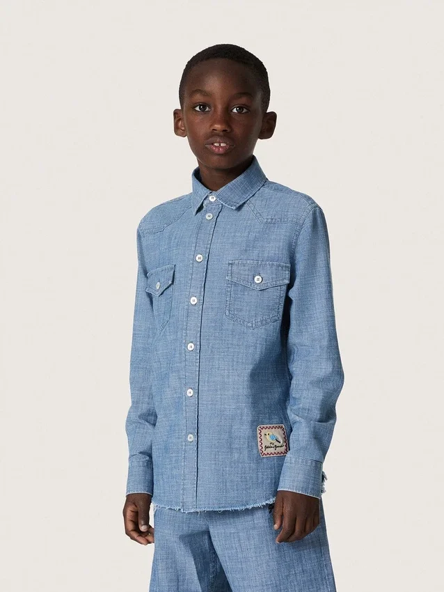 Camicia unisex Journey in chambray di cotone azzurro con orlo sfrangiato e toppa ricamata