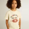 Camicie da bambino in bianco consumato con scritte multicolori
