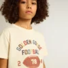 Camicie da bambino in bianco consumato con scritte multicolori