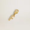 Ciondolo a forma di lettera F in ottone color oro con cristalli