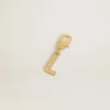 Ciondolo a forma di lettera L in ottone color oro con cristalli