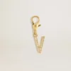 Ciondolo a forma di lettera V in ottone dorato con cristalli