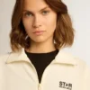 Felpa da donna bianca con zip, striscia bianca e stelle nere