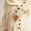 Felpa da donna bianca con zip, striscia bianca e stelle nere