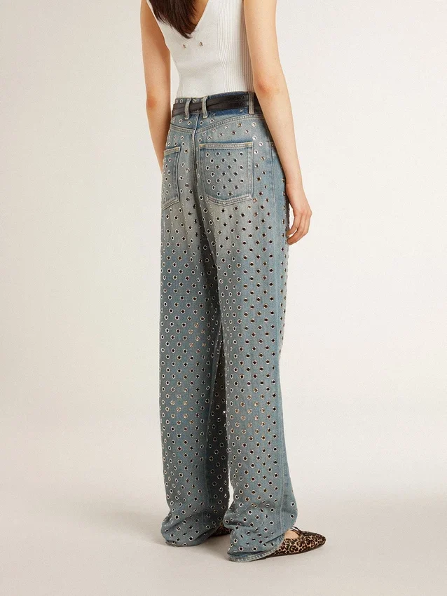 Jeans da donna lavati con occhielli su tutta la superficie