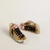 La giovane Francy Penstar in paillettes dorate con stella in pelle scamosciata grigio ghiaccio