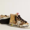 La giovane Francy Penstar in paillettes dorate con stella in pelle scamosciata grigio ghiaccio