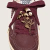 Lacci CNY Pellami in lana bordeaux con spilla a forma di fiore dorata