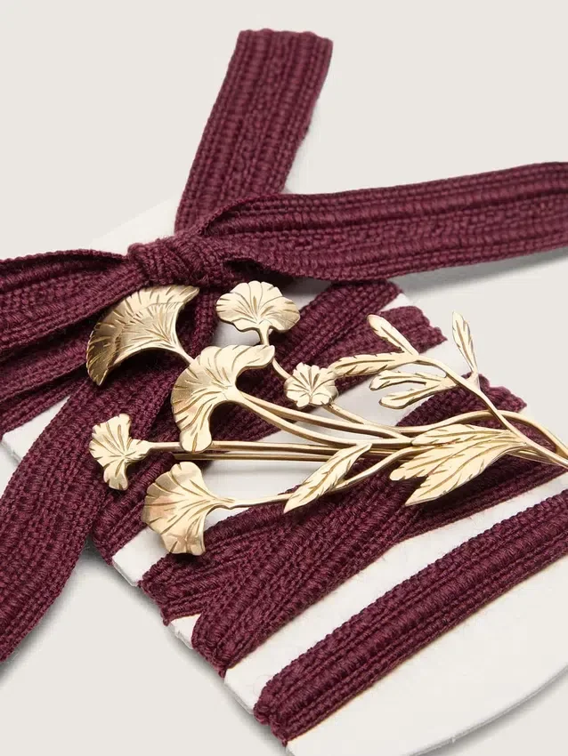 Lacci CNY Pellami in lana bordeaux con spilla a forma di fiore dorata