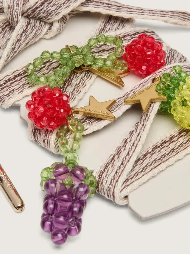 Lacci ricamati a righe color crema e grigio tortora con tre ciondoli a forma di frutto