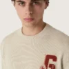 Maglione unisex a girocollo in cotone beige con toppa sul davanti e logo sul retro