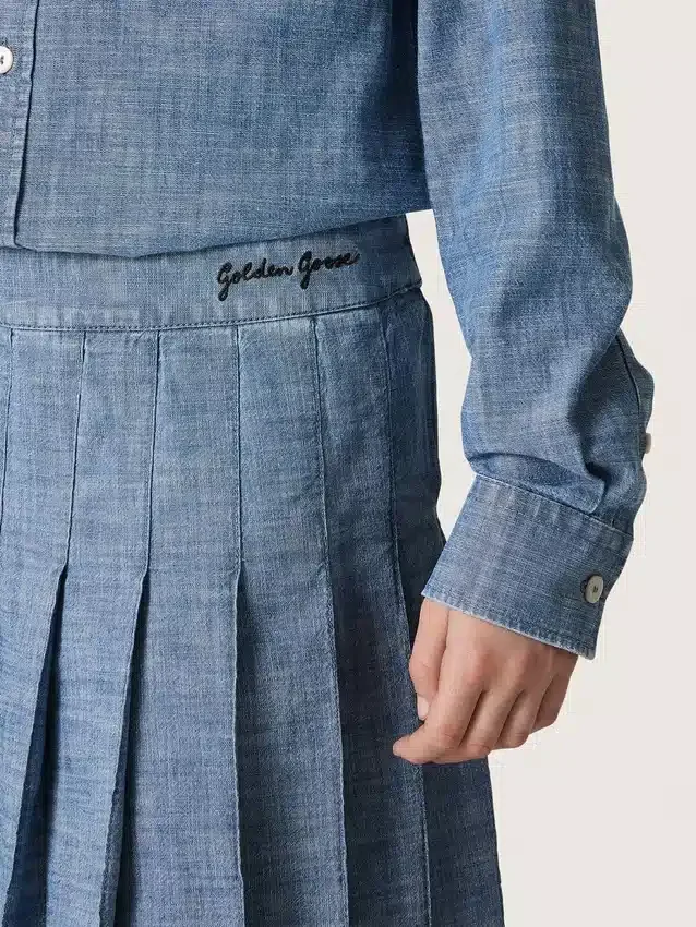 Minigonna a pieghe da bambina “Journey” in chambray di cotone azzurro con logo ricamato