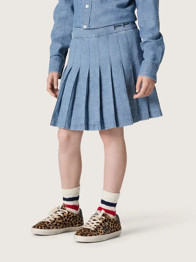 Minigonna a pieghe da bambina “Journey” in chambray di cotone azzurro con logo ricamato