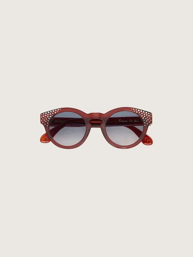 Occhiali da sole Cameron Panthos con montatura color miele, pietre preziose e lenti blu