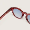 Occhiali da sole Cameron Panthos con montatura color miele, pietre preziose e lenti blu