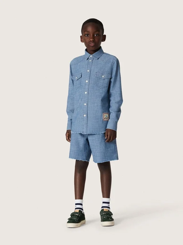 Camicia unisex Journey in chambray di cotone azzurro con orlo sfrangiato e toppa ricamata