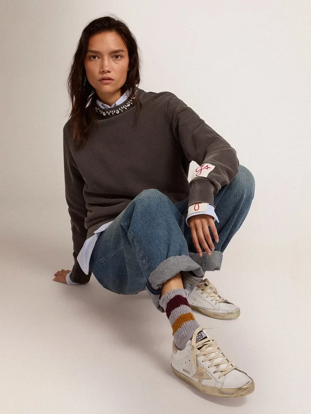 Super-Star da donna con bordo dorato scintillante e scritte con borchie metalliche