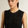 Top in maglia a rete nera con paillettes e dettagli a contrasto